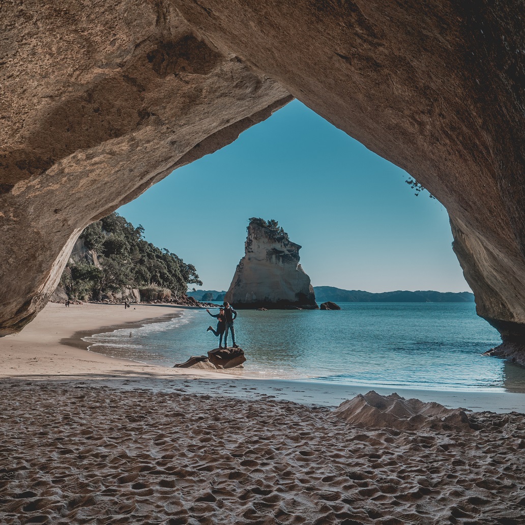 A travel couple at Cathedral Cove, Coromandel, Working Holiday in New Zealand
